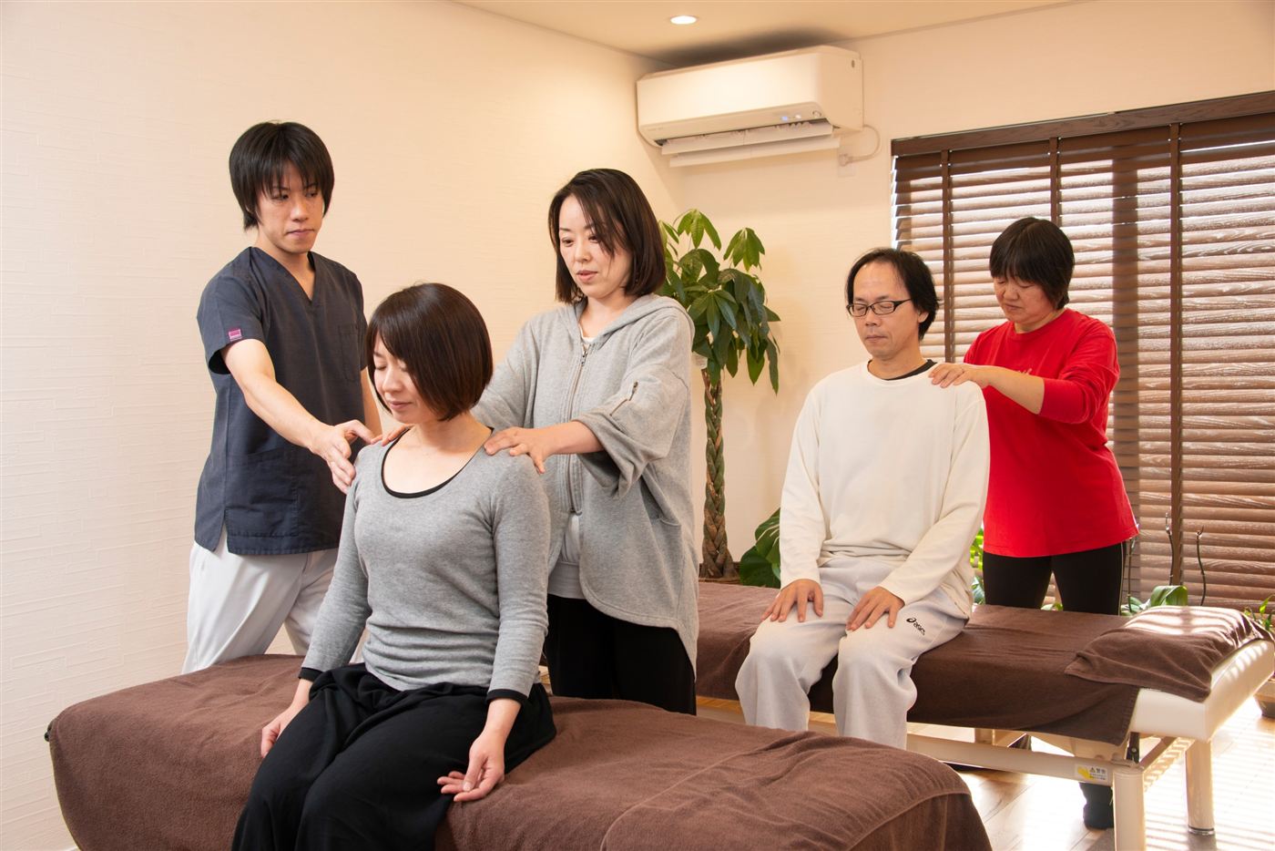 スクールで講師が受講生に手の当て方を教えている様子